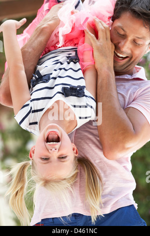 Father Holding Son Upside Down Outdoors Stock Photo