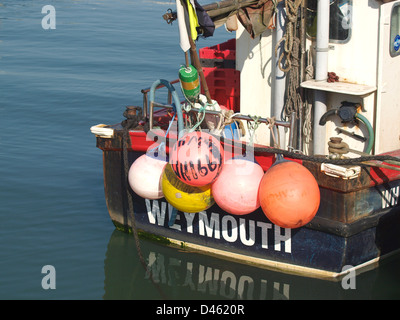 Colourful buoys and fenders on stern of fishing boat Stock Photo