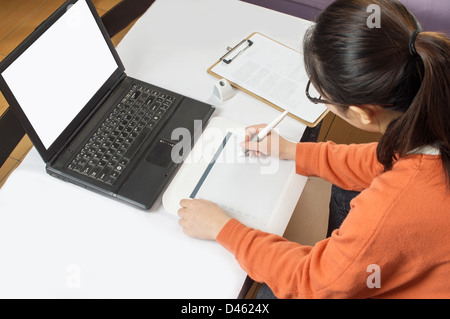 Female graphic designer working in office a using tablet pen. Stock Photo