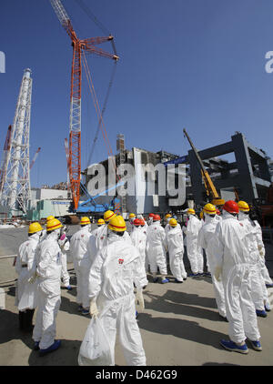 Fukushima, Japan. 6th March 2013. Members of the media wearing protective suits and masks are escorted by TEPCO employees as they visit near the No.4 reactor (C) and it's foundation construction (R) for storage of melted fuel rods at Tokyo Electric Power Co. (TEPCO)'s tsunami-crippled Fukushima Daiichi nuclear power plant in Fukushima prefectureahead of the second-year of the anniversary of the  March 11, 2011 tsunami and earthquake. Credit:  ZUMA Press, Inc. / Alamy Live News Stock Photo