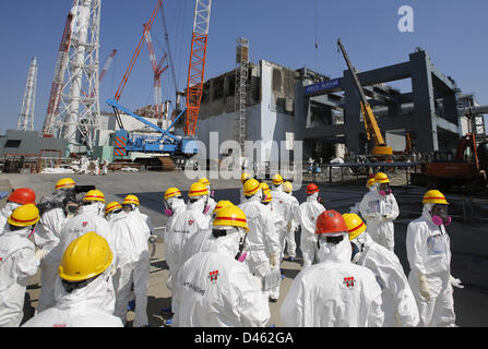 Fukushima, Japan. 6th March 2013. Members of the media wearing protective suits and masks are escorted by TEPCO employees as they visit near the No.4 reactor (C) and it's foundation construction (R) for storage of melted fuel rods at Tokyo Electric Power Co. (TEPCO)'s tsunami-crippled Fukushima Daiichi nuclear power plant in Fukushima prefectureahead of the second-year of the anniversary of the  March 11, 2011 tsunami and earthquake. Credit:  ZUMA Press, Inc. / Alamy Live News Stock Photo