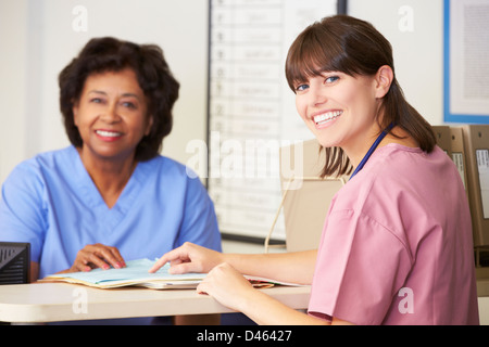 Two Nurses In Discussion At Nurses Station Stock Photo