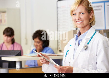 Female Doctor Using Digital Tablet At Nurses Station Stock Photo