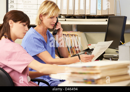 Nurse Using Digital Tablet At Nurses Station Stock Photo