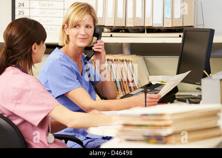 Two Nurses Working At Nurses Station Stock Photo