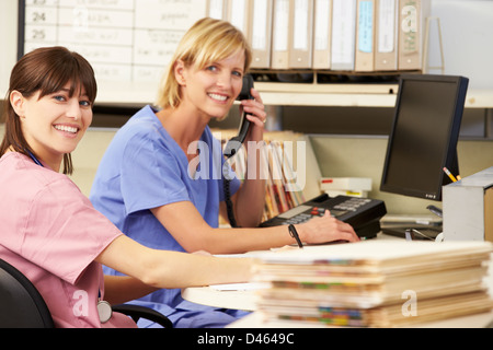 Two Nurses Working At Nurses Station Stock Photo