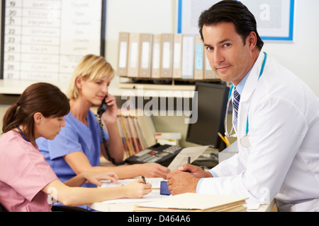 Doctor With Two Nurses Working At Nurses Station Stock Photo