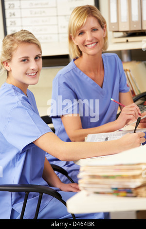 Two Nurses Working At Nurses Station Stock Photo