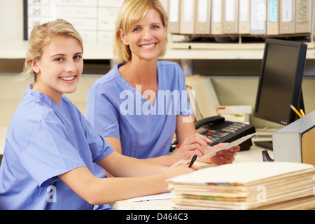 Two Nurses Working At Nurses Station Stock Photo