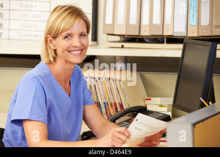 Portrait Of Nurse Working At Nurses Station Stock Photo