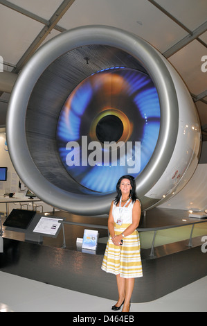 Sales girl stands in front of a Rolls Royce Trent 900 aero engine to give scale. The Trent series of engines are fitted to Airbus A380. Space for copy