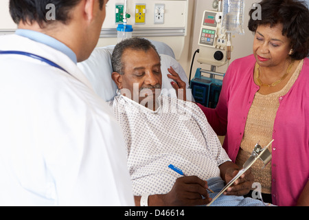 Doctor Explaining Consent Form To Senior Patient Stock Photo