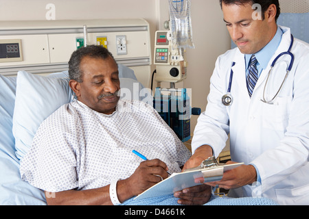 Doctor Explaining Consent Form To Senior Patient Stock Photo