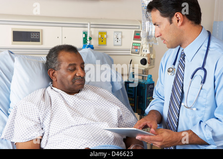 Doctor Using Digital Tablet In Consultation With Senior Patient Stock Photo