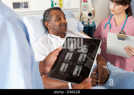 Doctor Using Digital Tablet In Consultation With Senior Patient Stock Photo