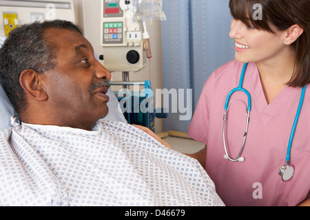 Nurse Talking To Senior Male Patient On Ward Stock Photo