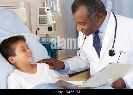 Doctor Visiting Child Patient On Ward Stock Photo 