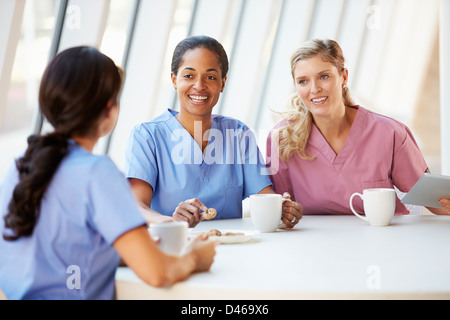 Group Of Nurses Chatting In Modern Hospital Canteen Stock Photo