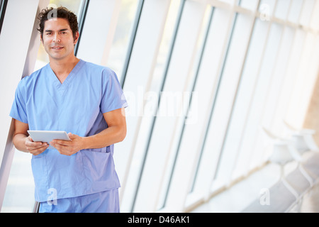 Doctor Using Digital Tablet In Corridor Of Modern Hospital Stock Photo