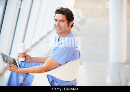 Doctor Using Digital Tablet On Coffee Break In Hospital Stock Photo