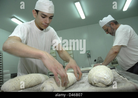 A worker of the bakery, elaboration of artisan bread in the bakery Stock Photo