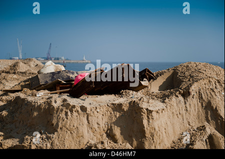 Metal piles and other materials laying in the sand ready to use on the repair of the seafront at Lowestoft. Stock Photo