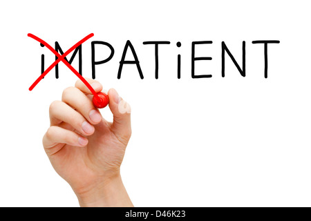Hand turning the word Impatient into Patient with red marker on transparent wipe board. Stock Photo