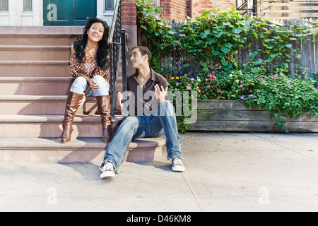 He makes her laugh. (Some motion blur on her). Photo taken in greenwich village in New York on a lazy afternoon. Stock Photo