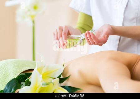 Beautiful woman having a wellness back massage and feeling visibly good about it Stock Photo