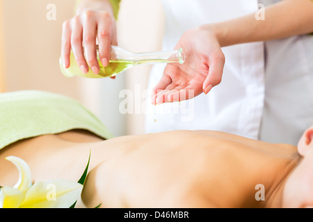 Beautiful woman having a wellness back massage and feeling visibly good about it Stock Photo