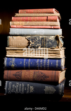 A stack of antique books sit on a shelf. Stock Photo