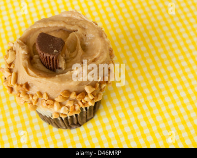 Gourmet Reese's peanut butter cups cupcake on yellow backround. Stock Photo