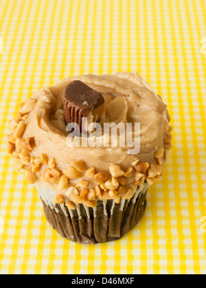 Gourmet Reese's peanut butter cups cupcake on yellow backround. Stock Photo