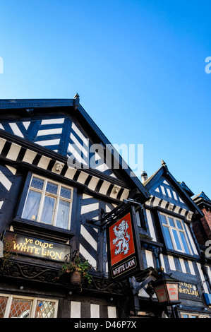 Old traditional English pub from the Tudor era, showing pub sign and half timbered ('black and white') construction. Stock Photo