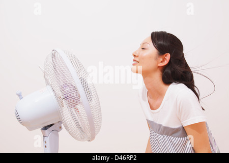 Woman Cooling Down With a Fan Stock Photo