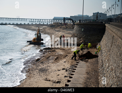 Workmen repairing the sea defence wall at Lowestoft Suffolk Stock Photo