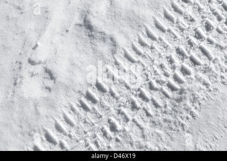 Background texture with tire tracks on road covered with snow Stock Photo