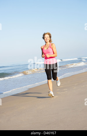 Senior Woman Exercising On Beach Stock Photo