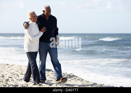 Senior Couple Walking Along Beach Together Stock Photo