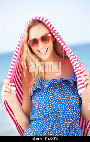 Woman Sheltering From Sun On Beach Holiday Stock Photo