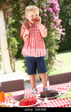 Boy Eating Jelly And Cake At Outdoor Tea Party Stock Photo