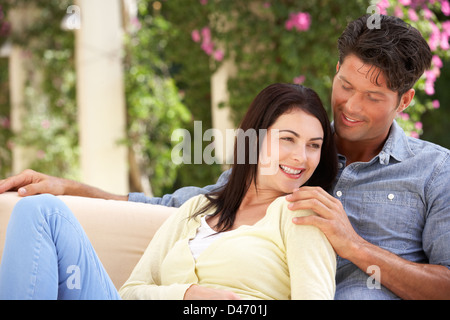 Couple Relaxing On Sofa At Home Stock Photo