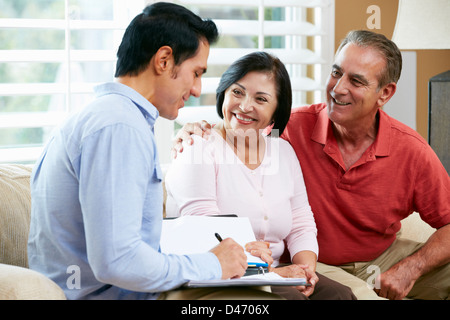 Financial Advisor Talking To Senior Couple At Home Stock Photo