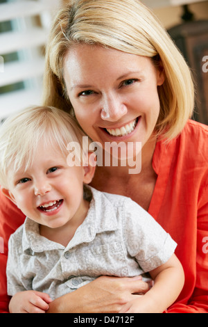 Portrait Of Mother And Son Sitting On Sofa At Home Stock Photo