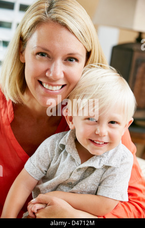 Portrait Of Mother And Son Sitting On Sofa At Home Stock Photo