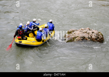 Young tourists practice rafting with a guide in Sella river in an inflatable boat in Asturias, Spain. Stock Photo