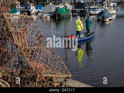 Lymington Harbour, Two men standing in small boat, Hampshire, England, UK. Europe Stock Photo
