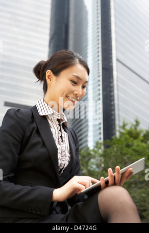 Chinese Businesswoman Working On Tablet Computer Outside Office Stock Photo