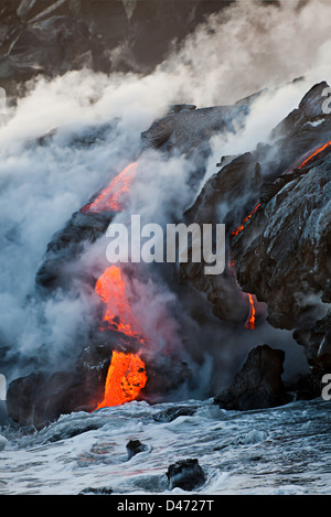 The Pahoehoe lava flowing from Kilauea has reached the Pacific ocean near Kalapana, Big Island, Hawaii. Stock Photo