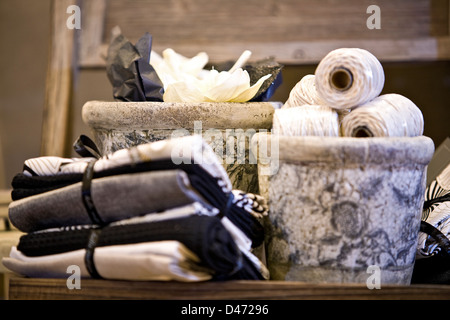 Interior image of neatly folded and tied kitchen towels placed near ceramic pots with rolls of string. Stock Photo
